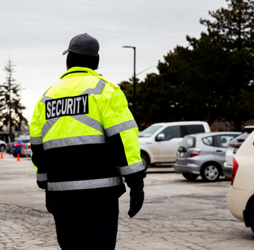 A rear view of a security guard watching over the parking area